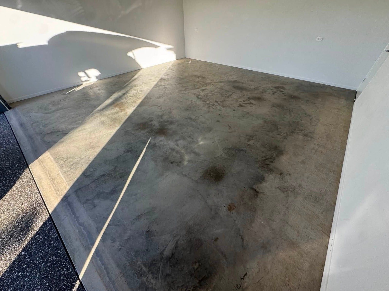 Bare, stained concrete slab before preparation