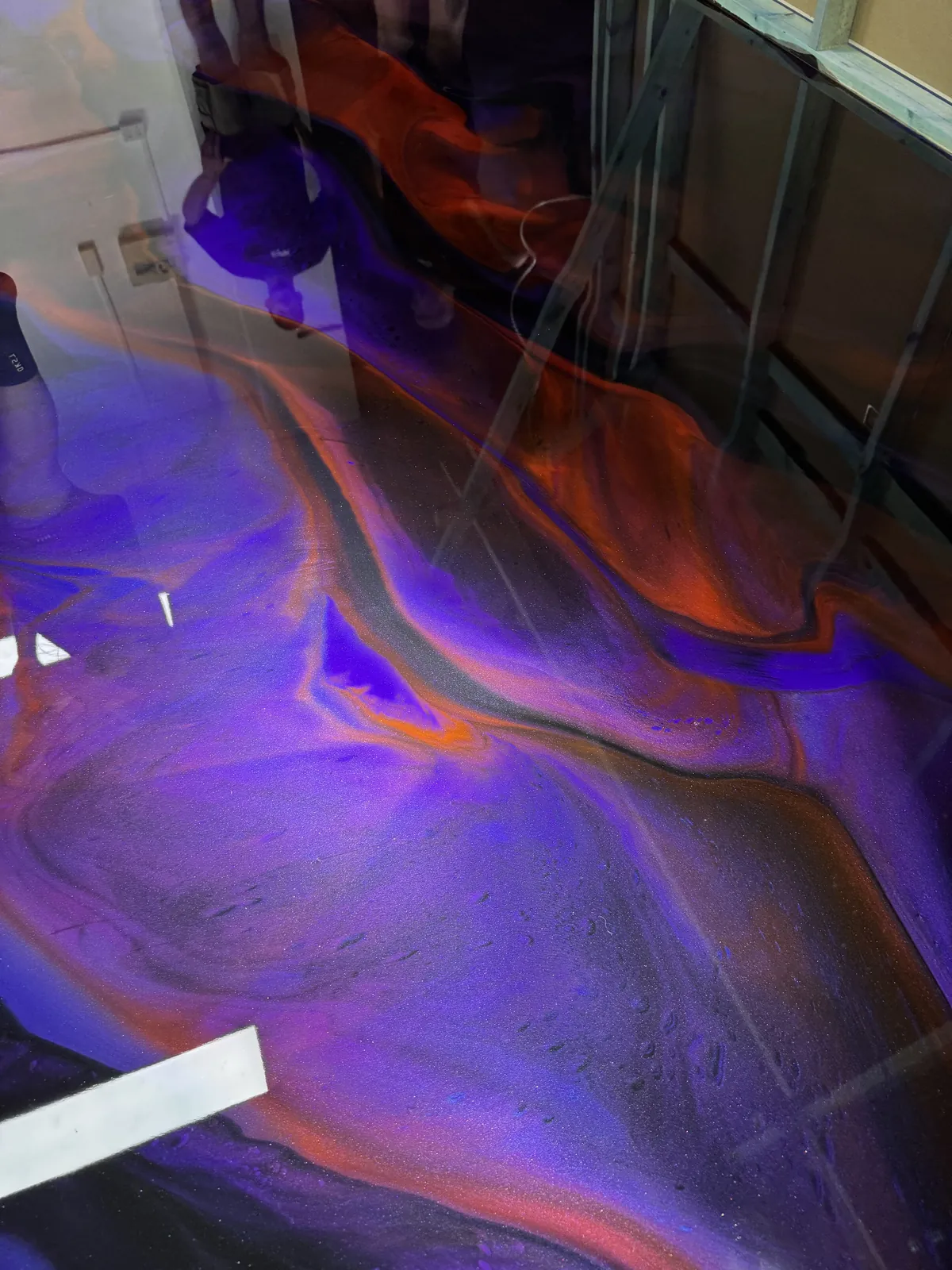 Close view of a purple and orange metallic epoxy floor, showing the marbled 3D depth under the gloss coat